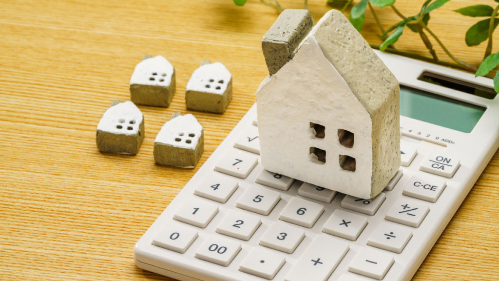 The image shows a house and a calculator to give the impressions of budgeting