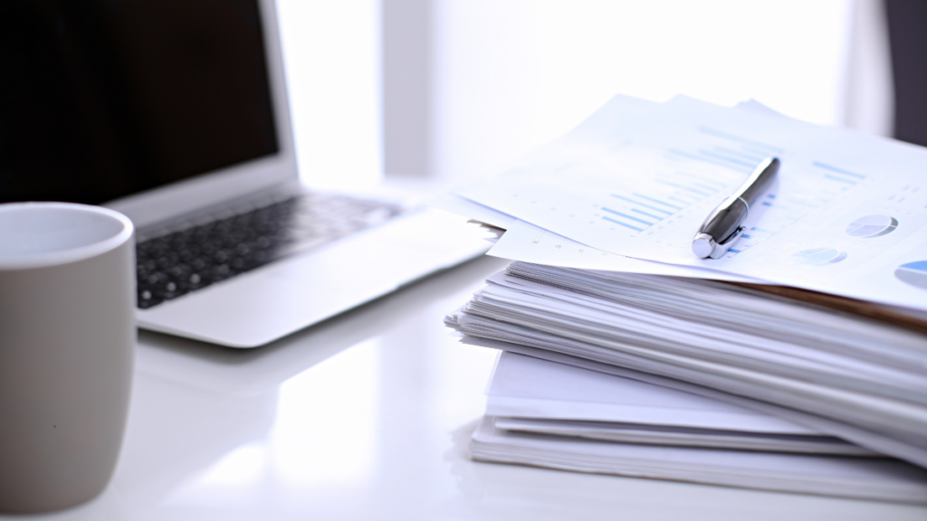 Image showing a laptop, coffee and paperwork.